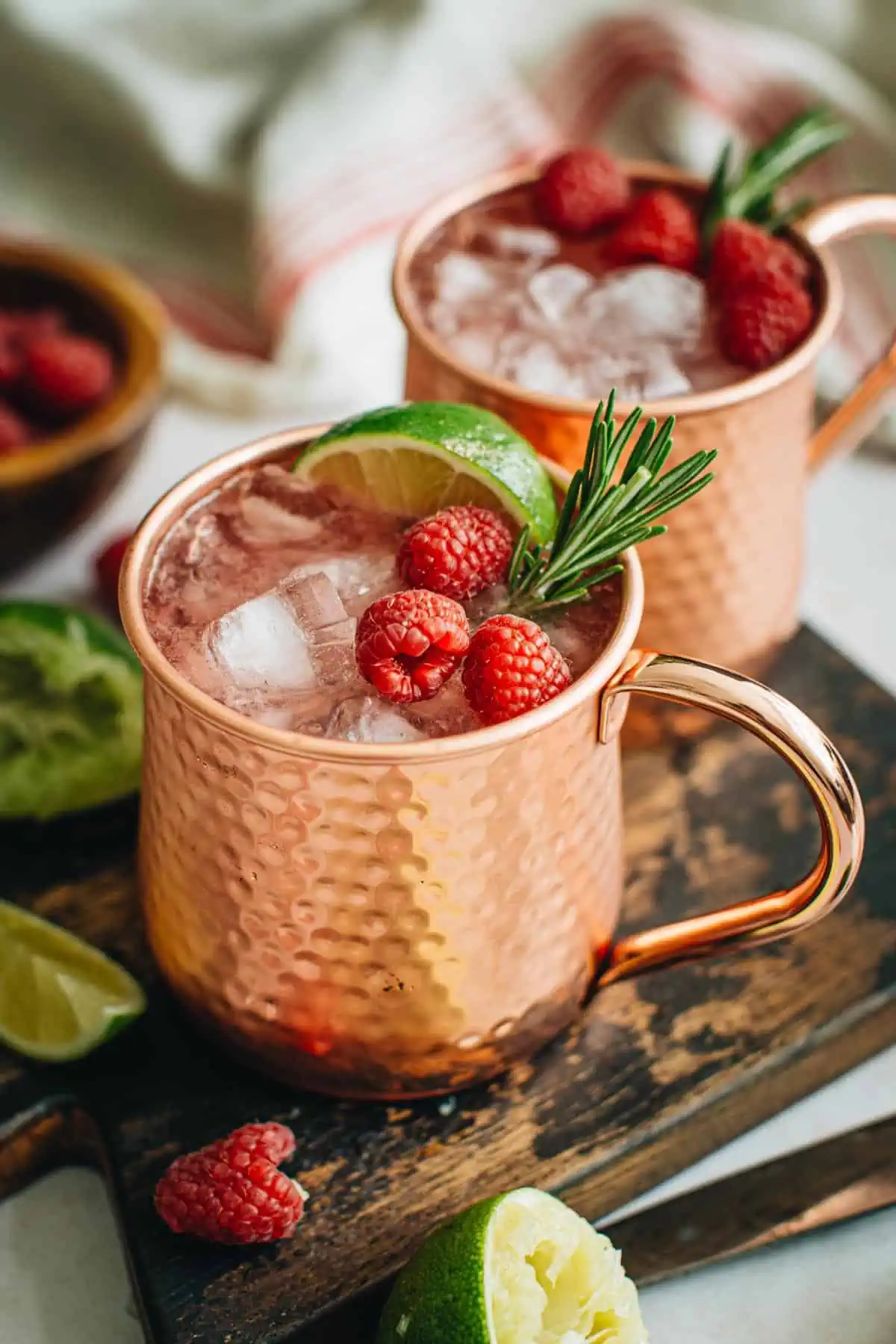 Raspberry mule with fresh raspberries and a lime wedge.