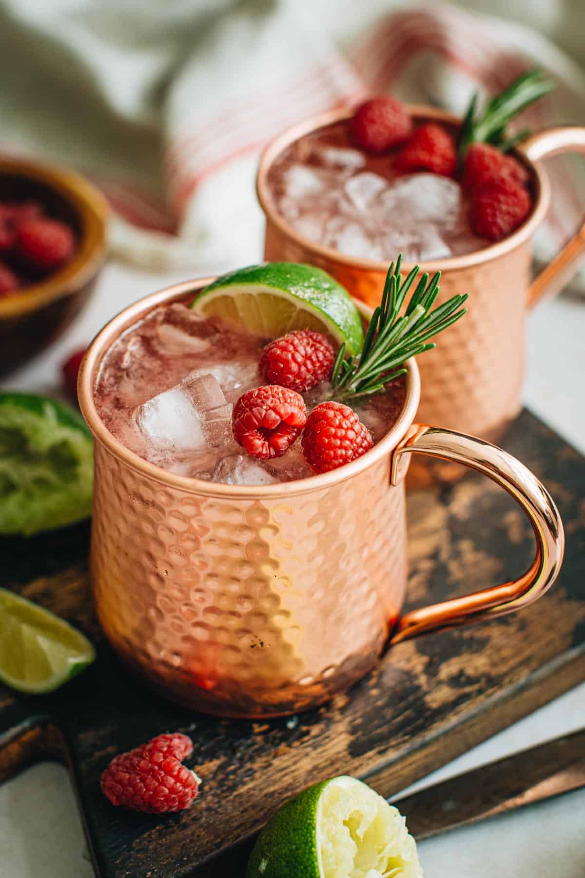 Raspberry Moscow Mule with fresh raspberries and rosemary as a garnish.