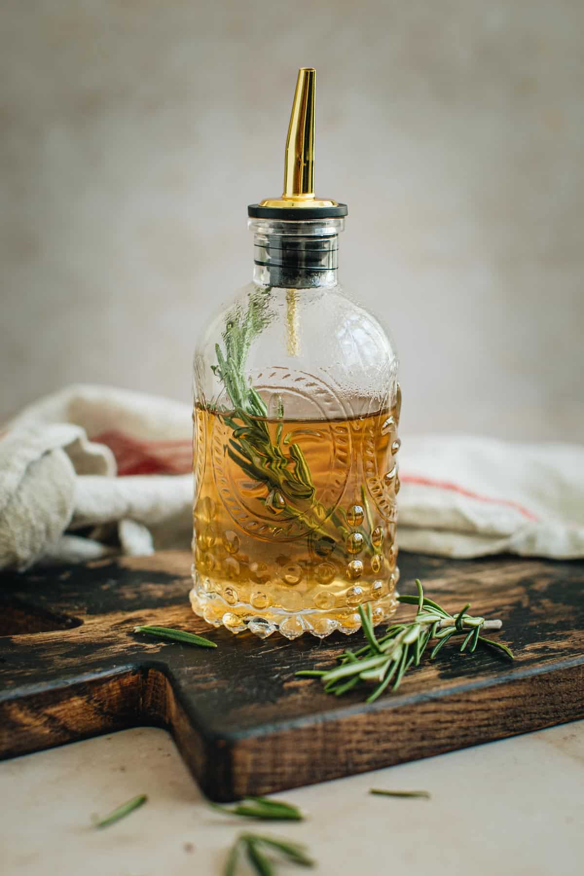 Rosemary simple syrup in a bottle with a spout.