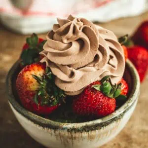Homemade chocolate whipped cream over strawberries.