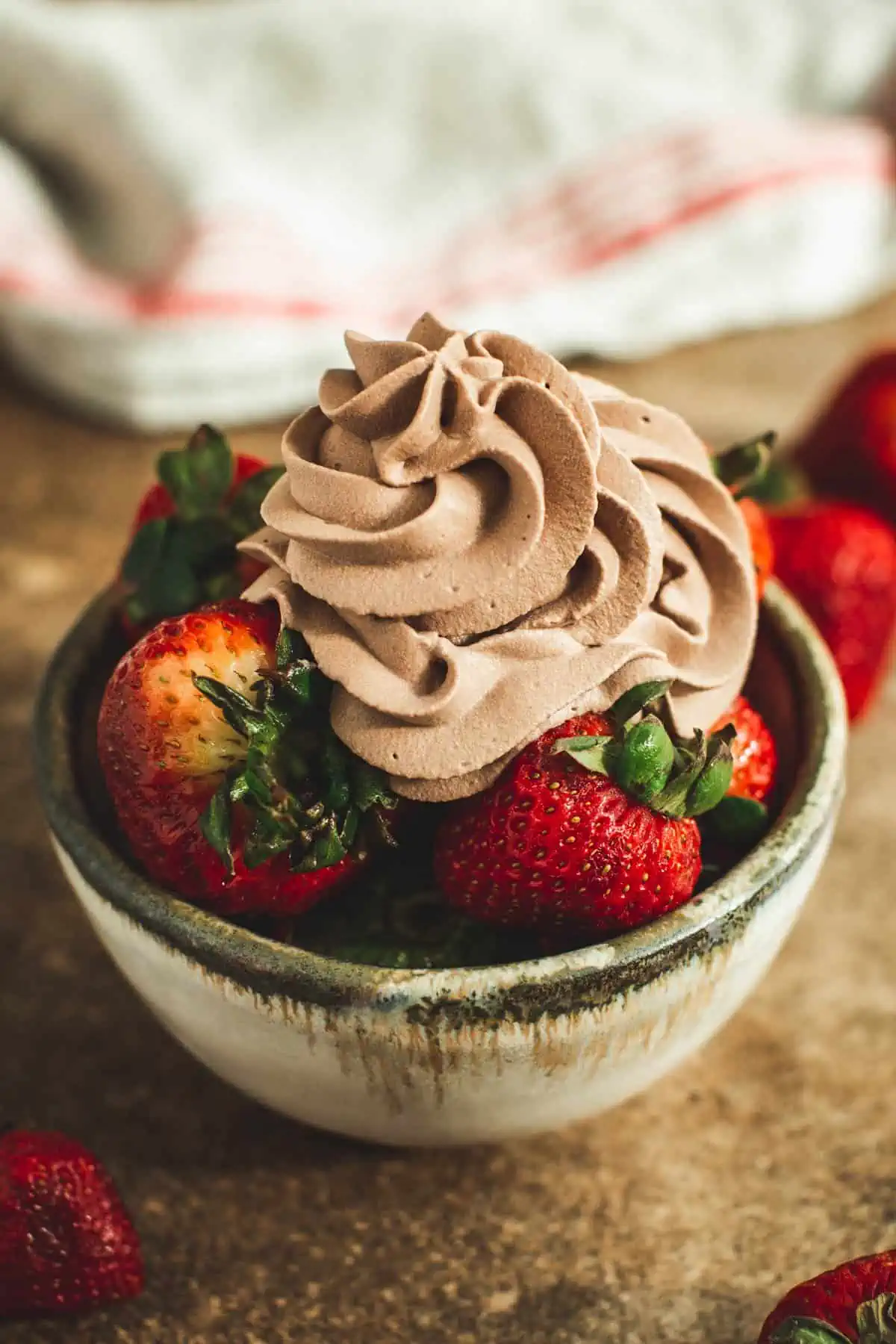 Homemade chocolate whipped cream over strawberries.