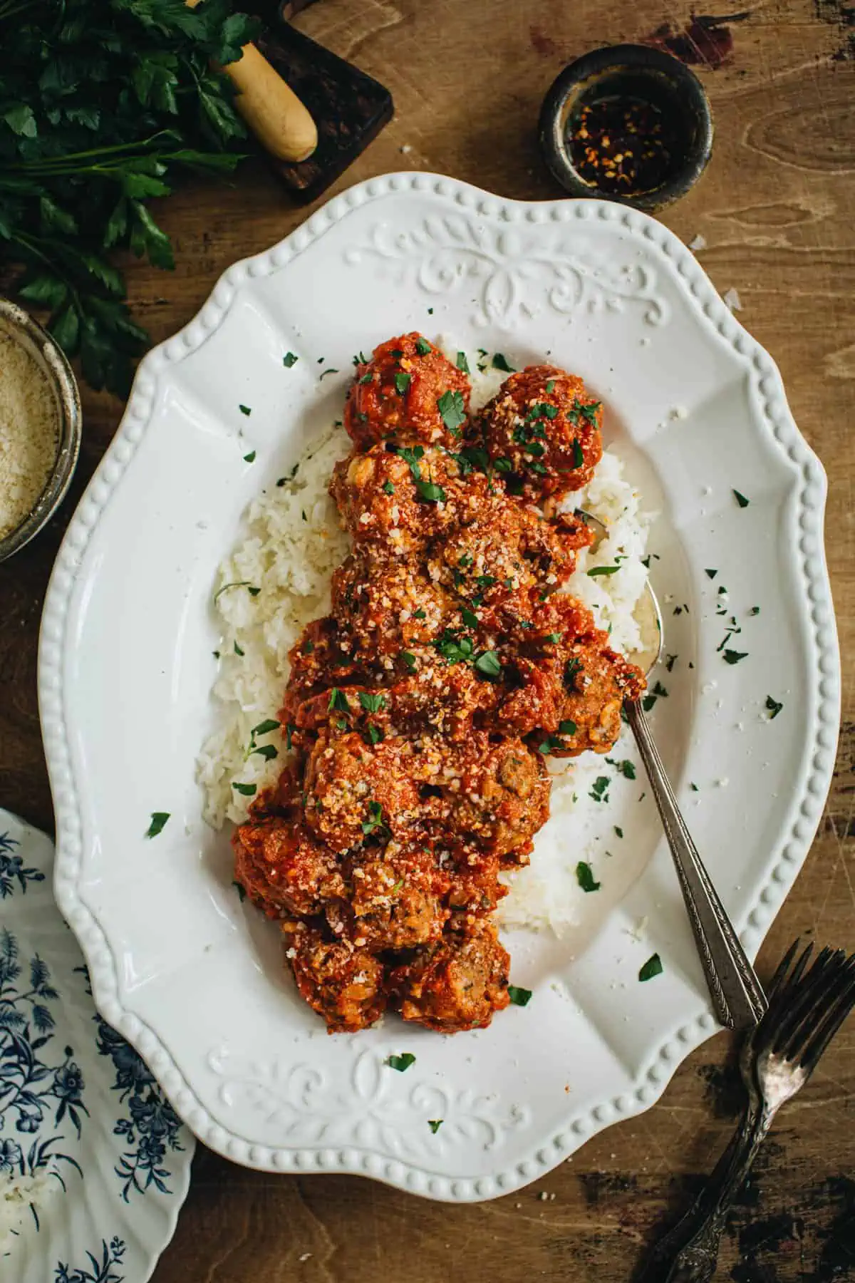 Meatballs and rice on a platter with a serving spoon.