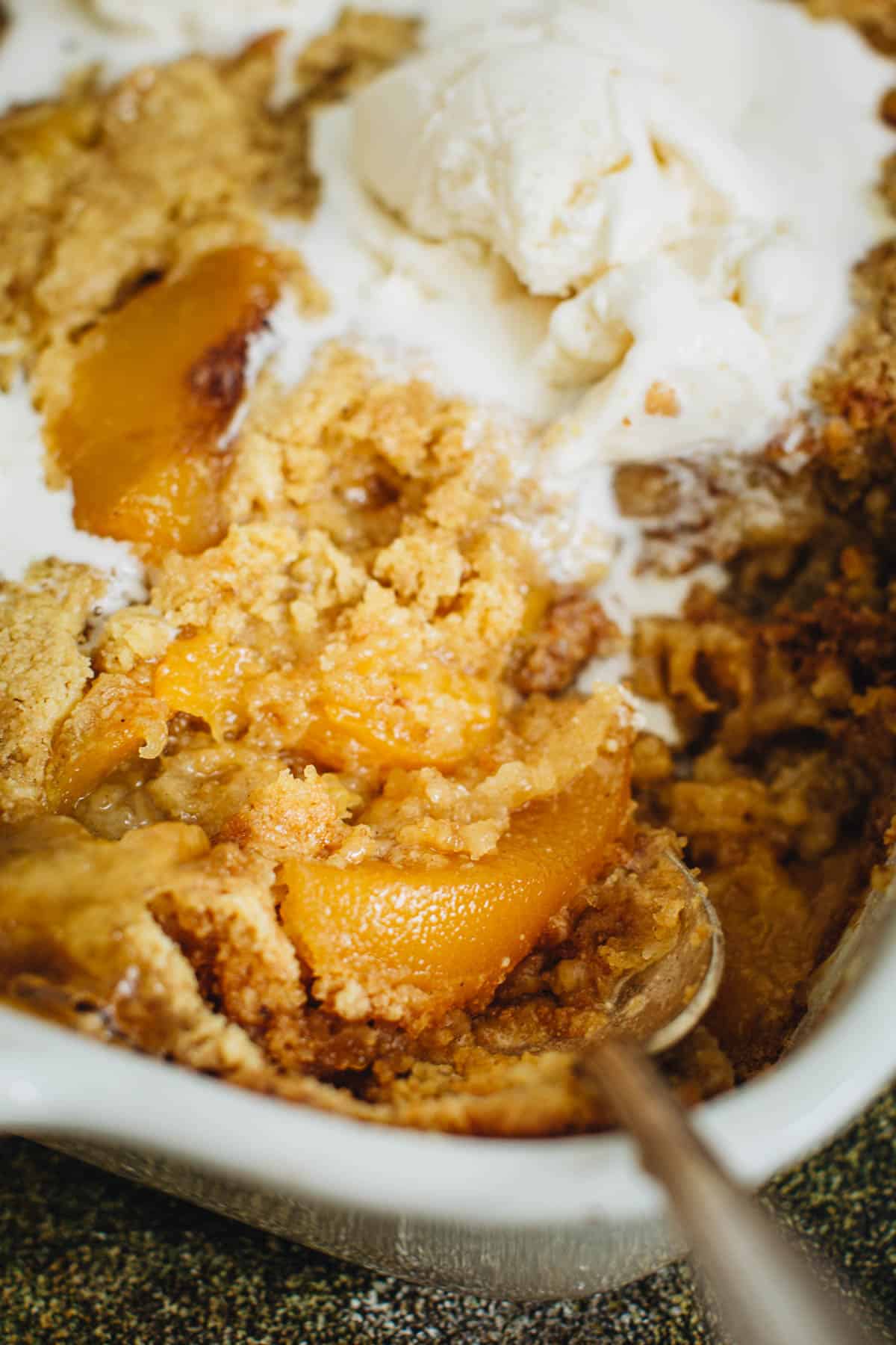 Peach cobbler topped with ice cream.