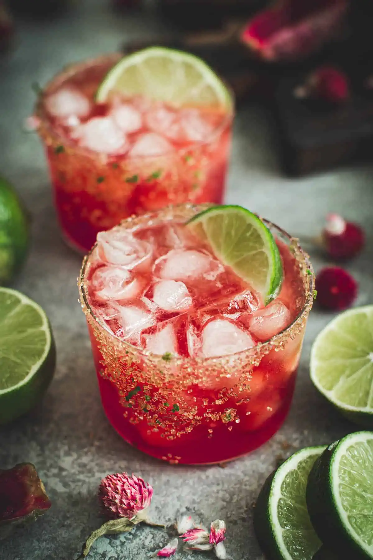 Prickly pear margaritas with lime wedges and sugared rims.