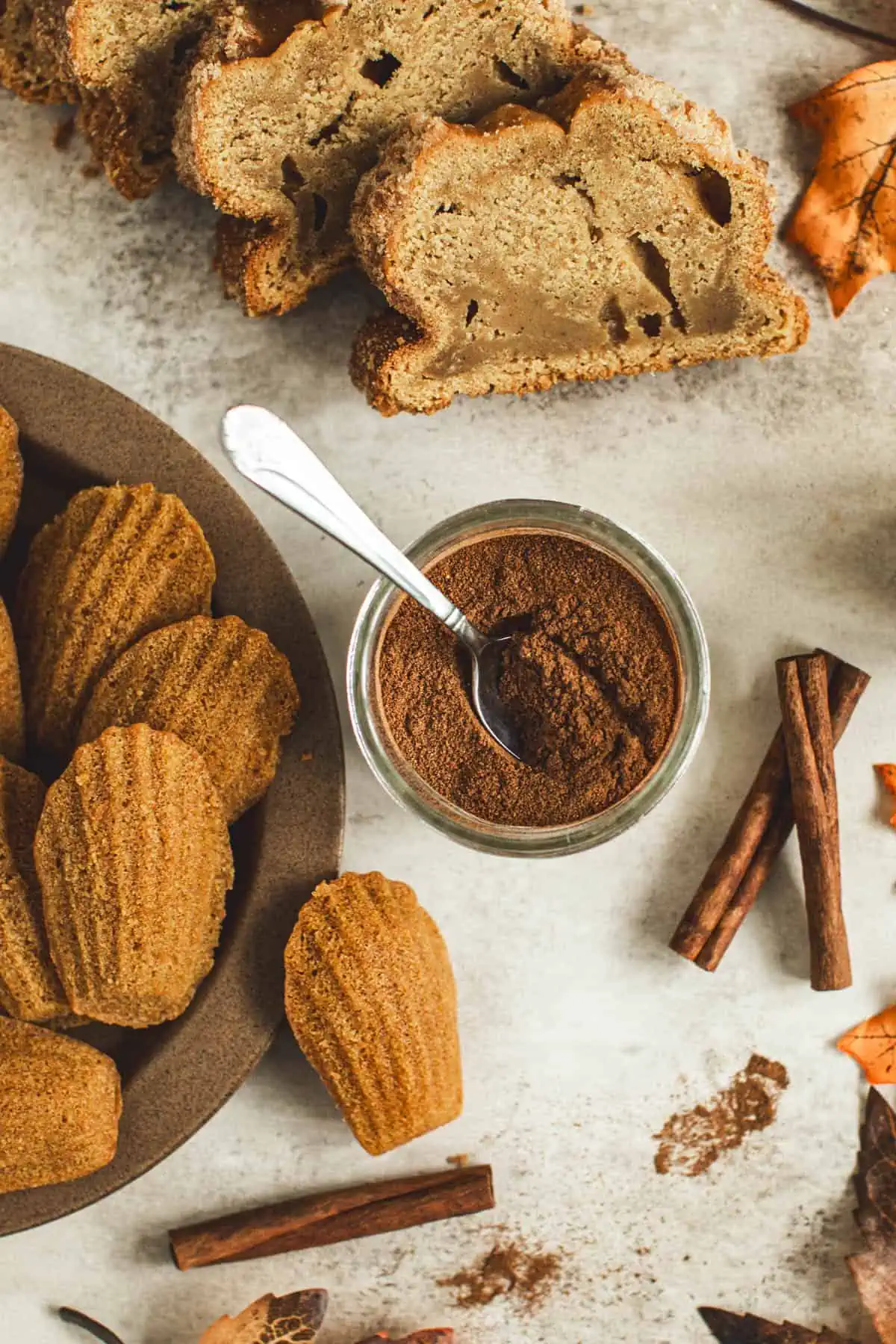 Pumpkin pie spice in a glass jar with a spoon.