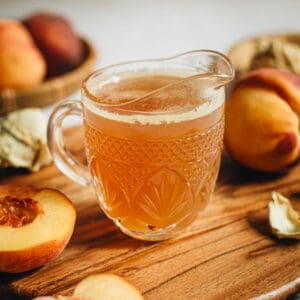 Peach syrup in a glass cup.