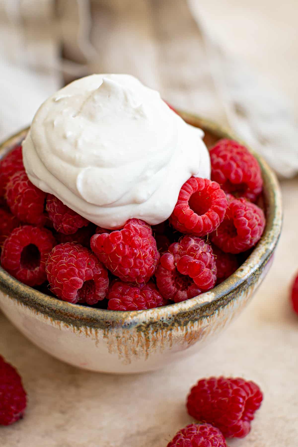 Coconut whipped cream over raspberries.