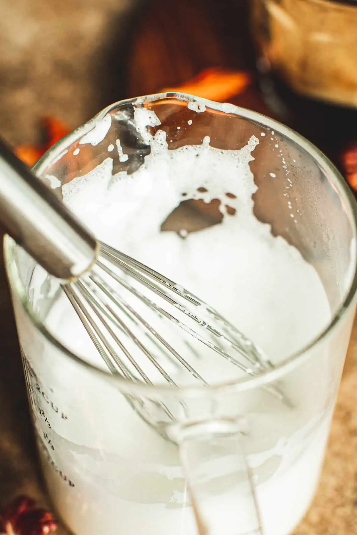 Frothing milk with a whisk.