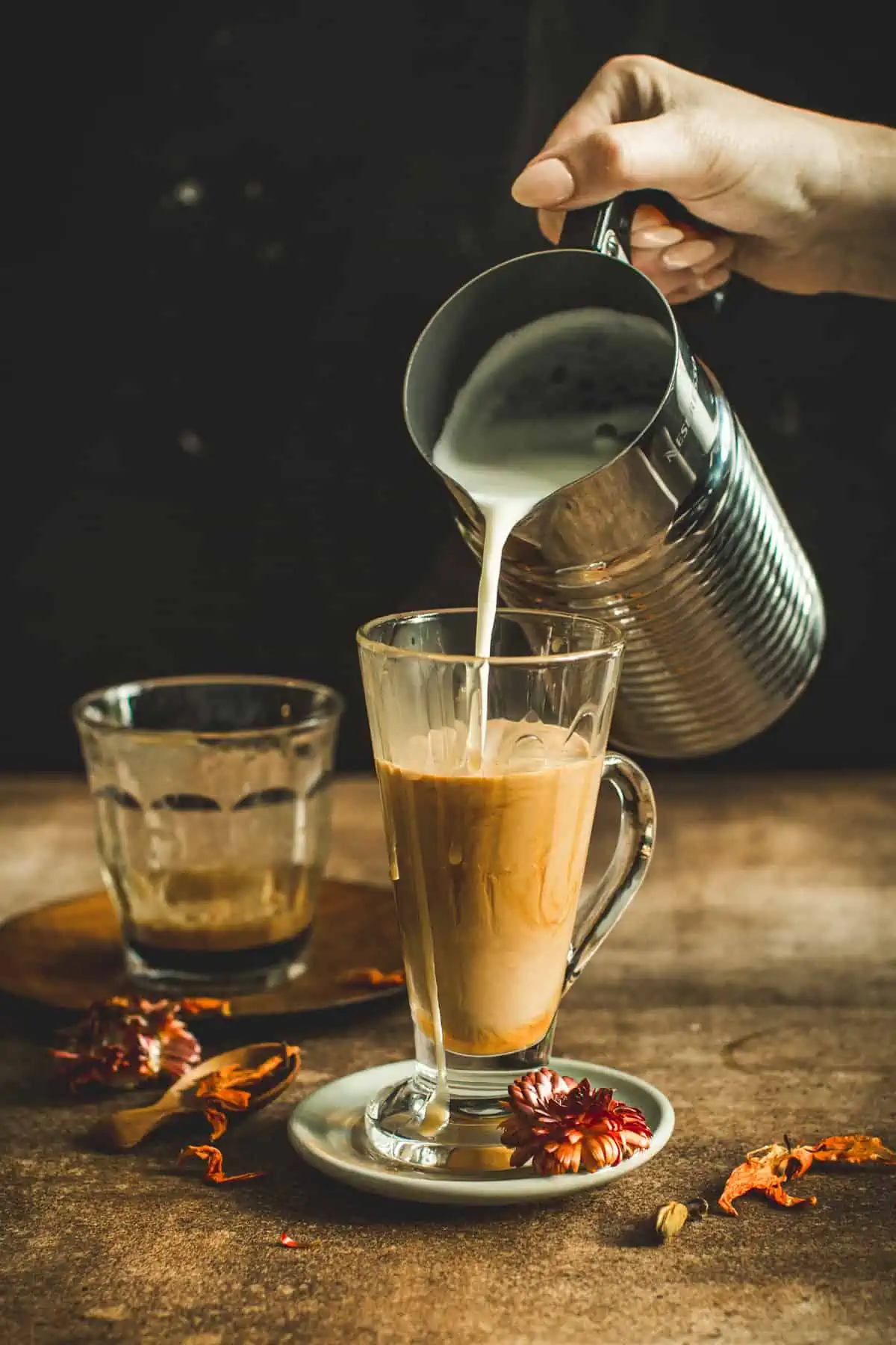 Pouring frothed milk into a latte.