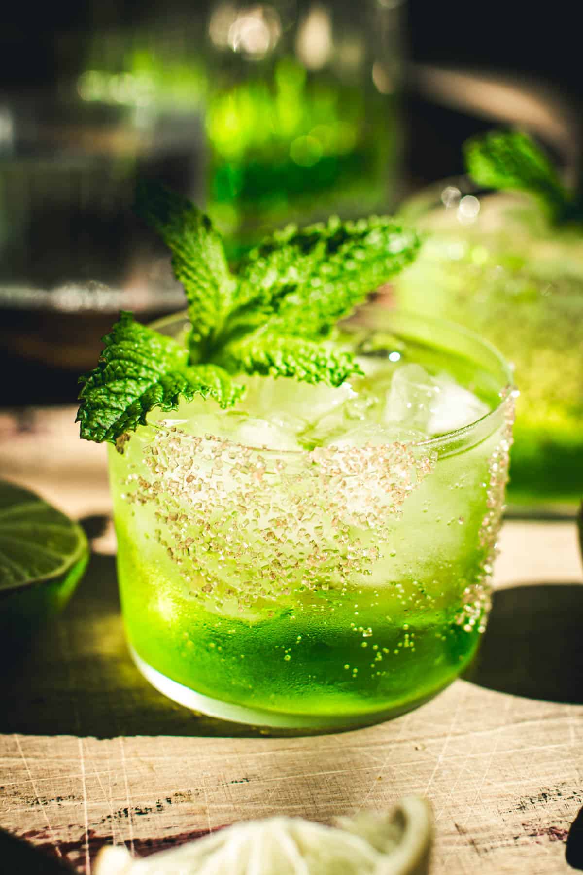Midori cocktail with a mint leaf garnish.