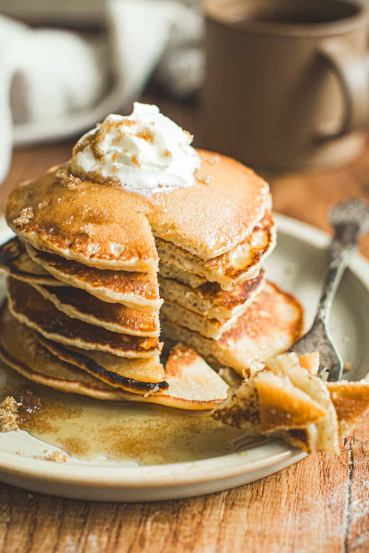 Pancakes with brown sugar and topped with whipped cream and maple syrup.