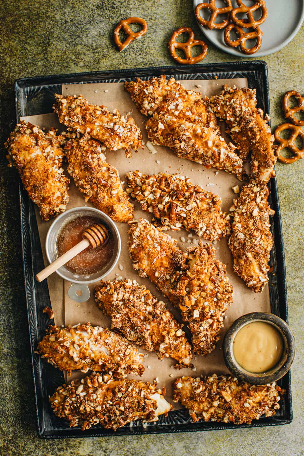 Pretzel crusted chicken tenders on a tray.