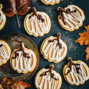 Pumpkin sugar cookies covered in glazed icing.