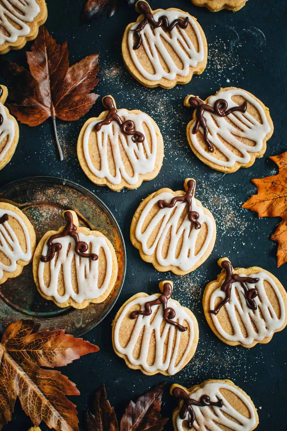 Pumpkin sugar cookies covered in glazed icing.