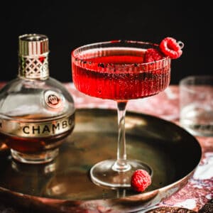 Vampire's kiss cocktail with a raspberry garnish.