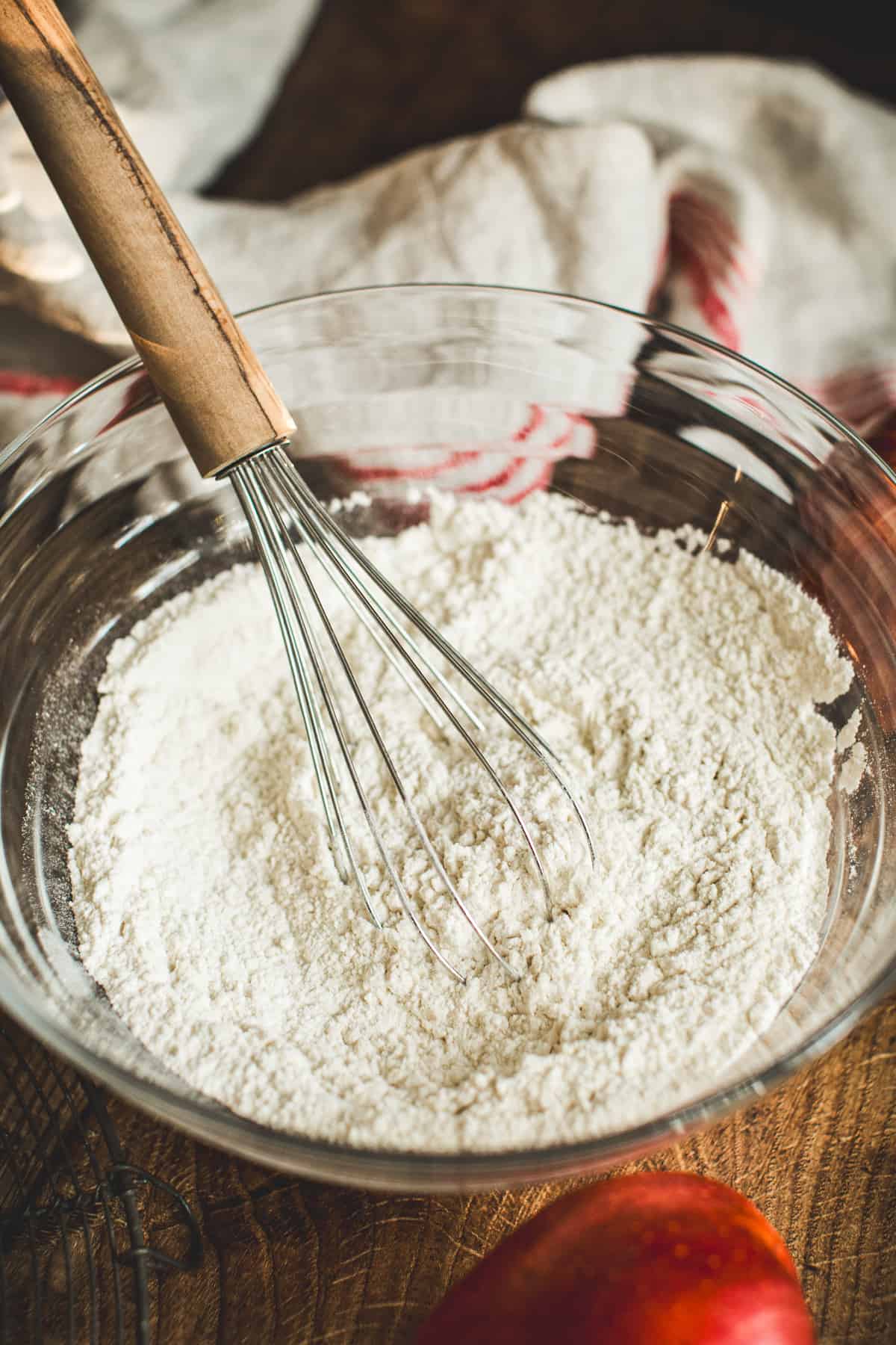 Dry ingredient mixture in a mixing bowl with a whisk for making Apple Cinnamon Muffins.