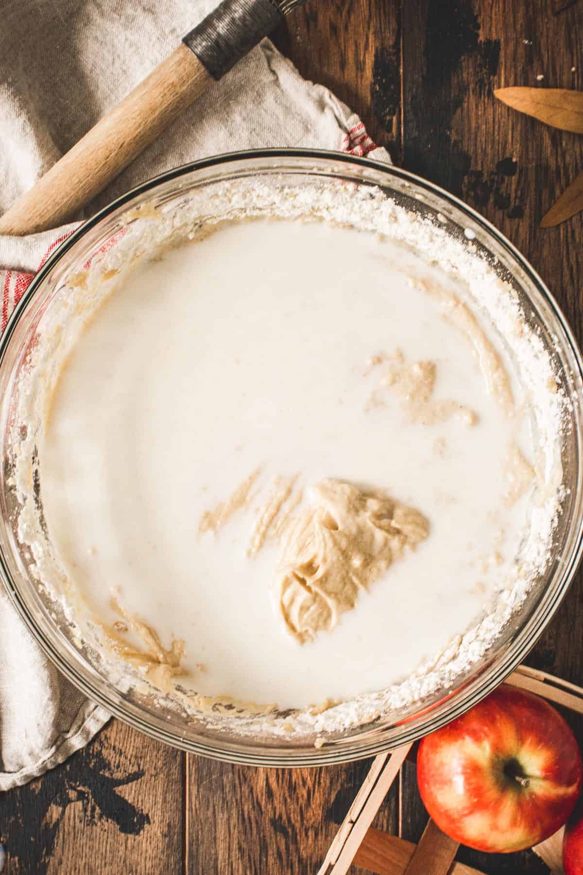 Milk and dry ingredients added to the batter for an apple crumb cake.