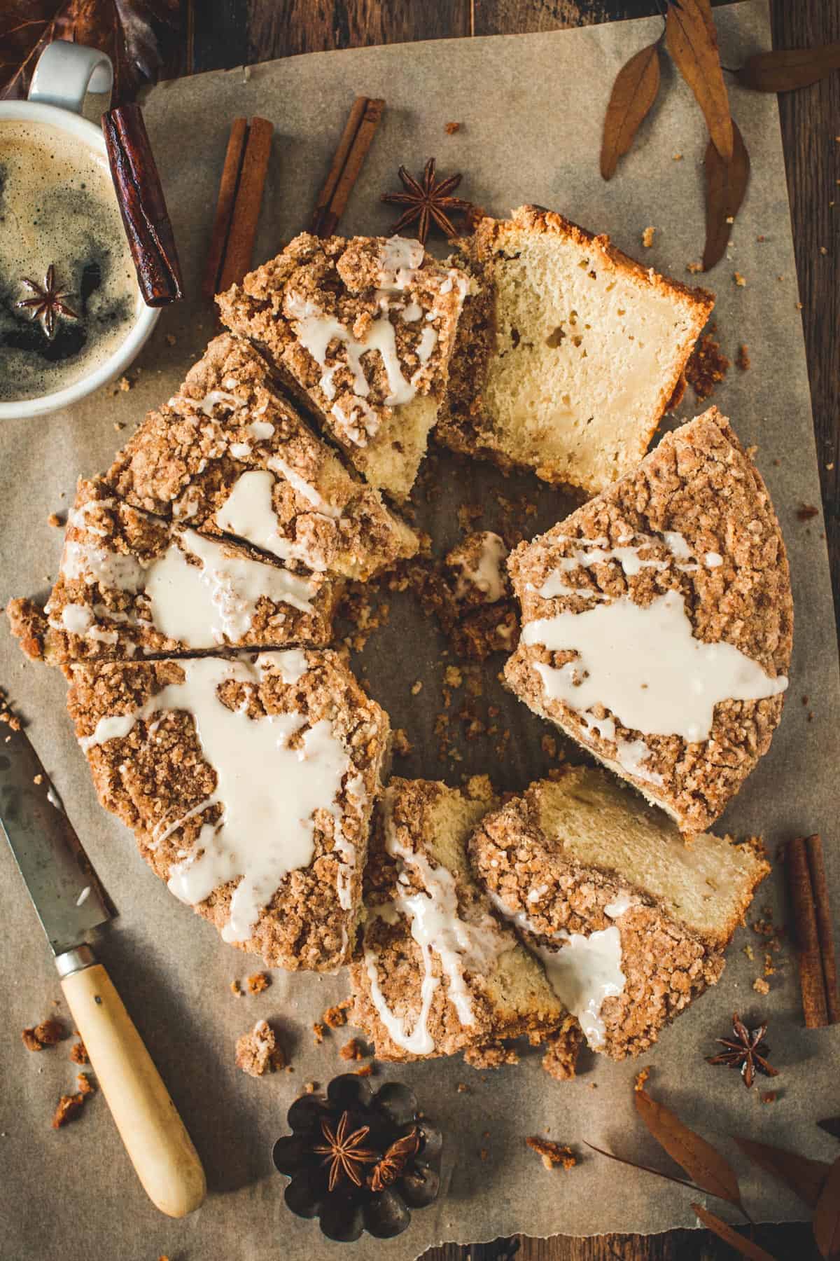 Sliced apple crumb cake with glaze drizzled on top.