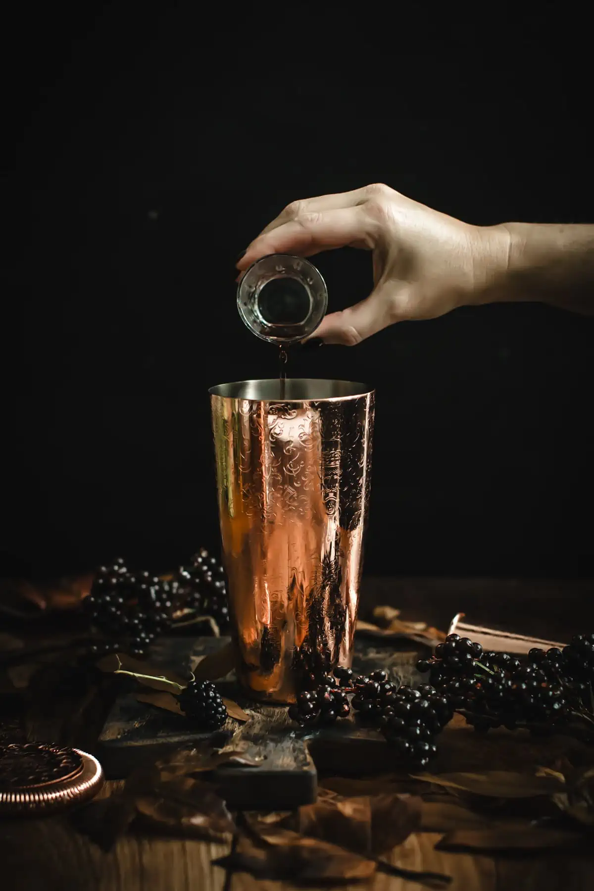 Adding Chambord to a cocktail shaker for making a Black Martini.