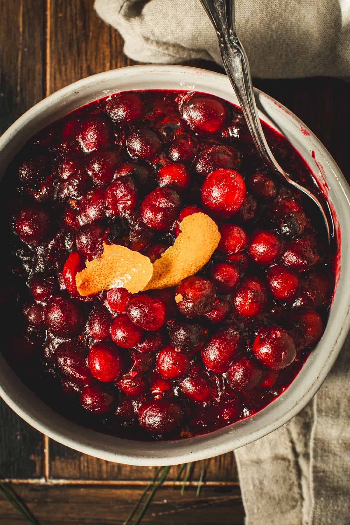 Bourbon cranberry sauce topped with orange peel in a bowl.