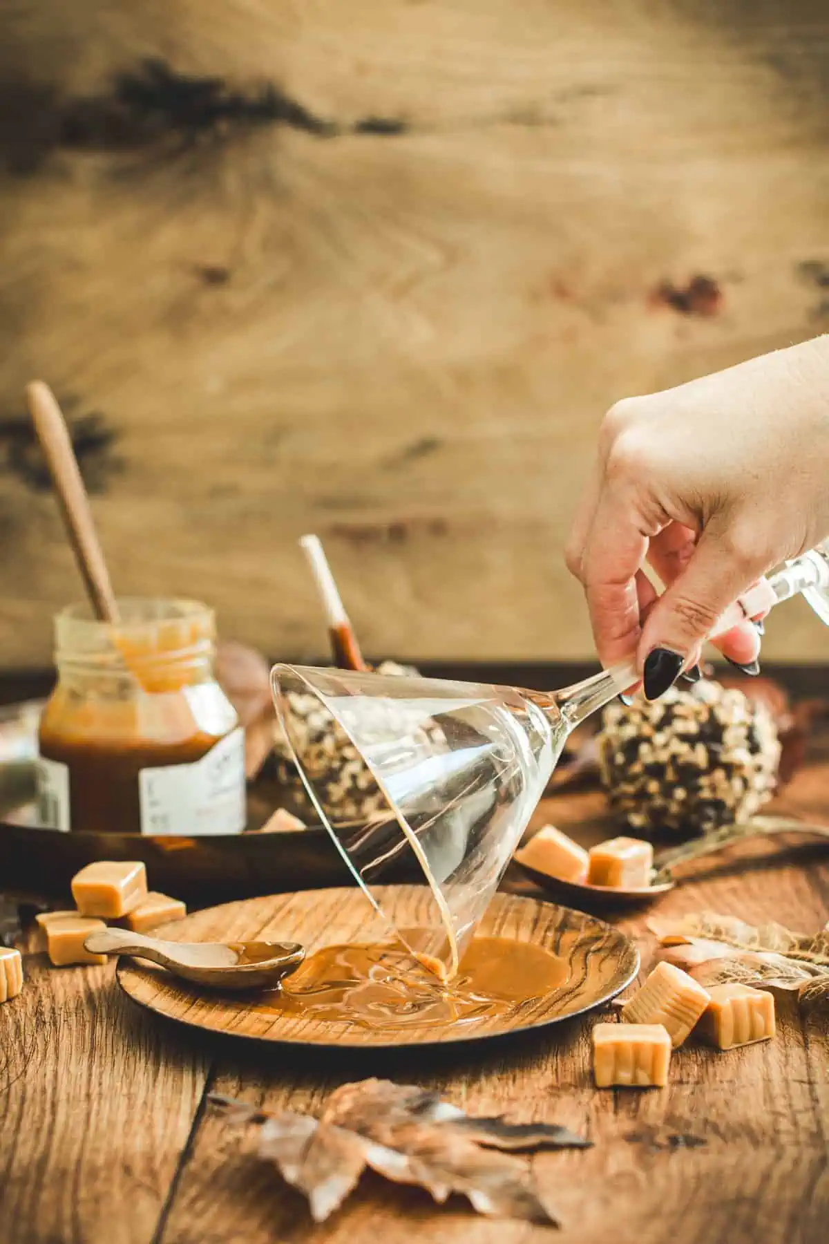 Martini glass rim dipping into caramel sauce for a caramel apple martini.