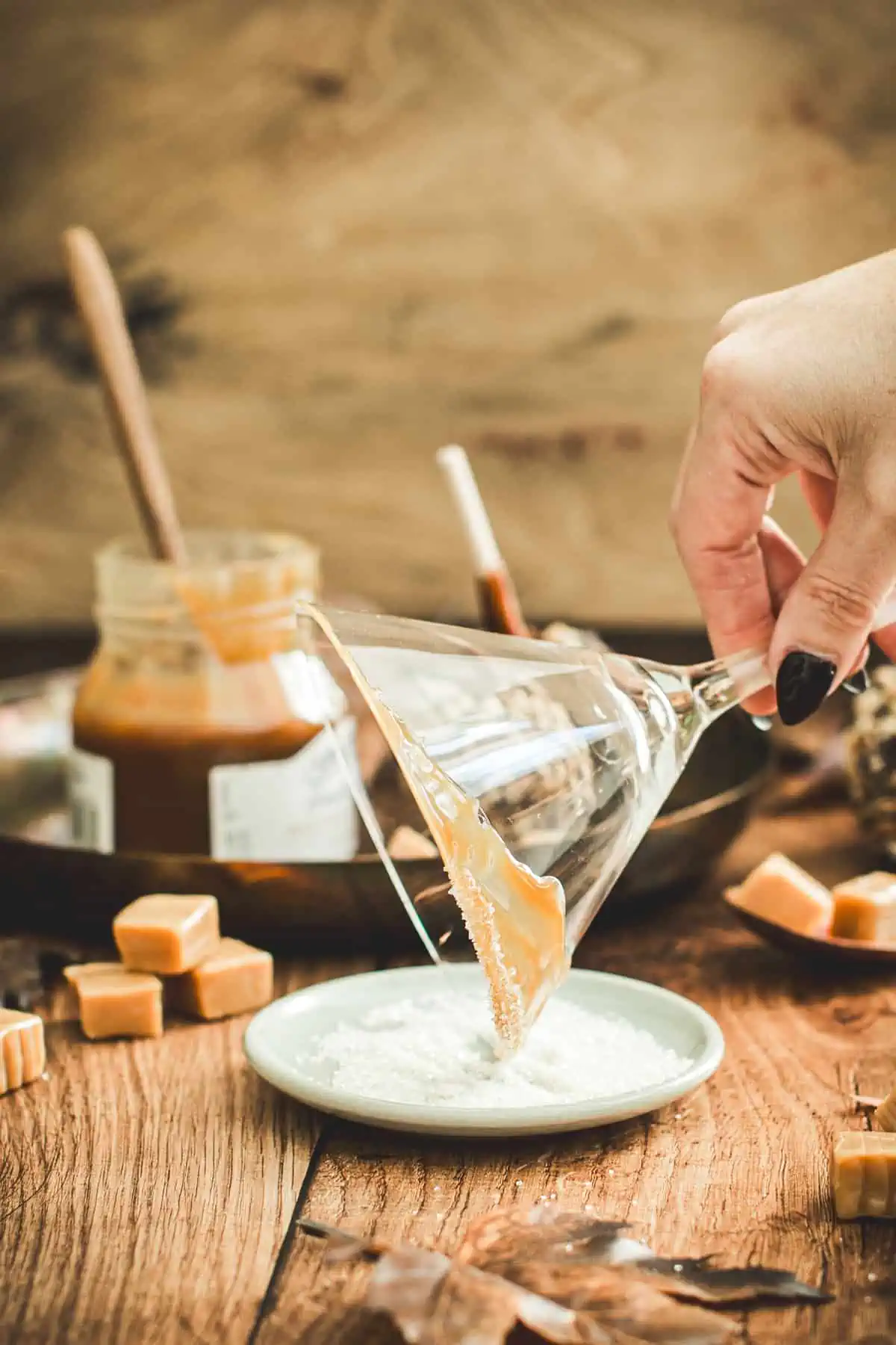 Coated martini glass rim dipping into sugar for a caramel apple martini.