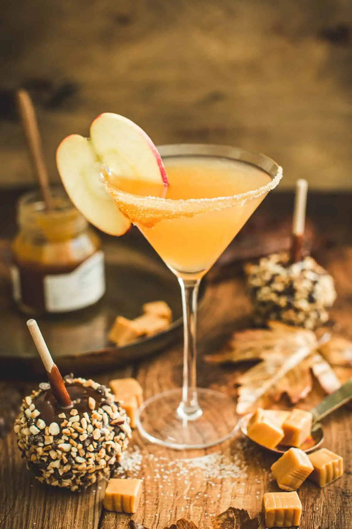 Caramel apple martini with a sugared glass rim and an apple slice for garnish.