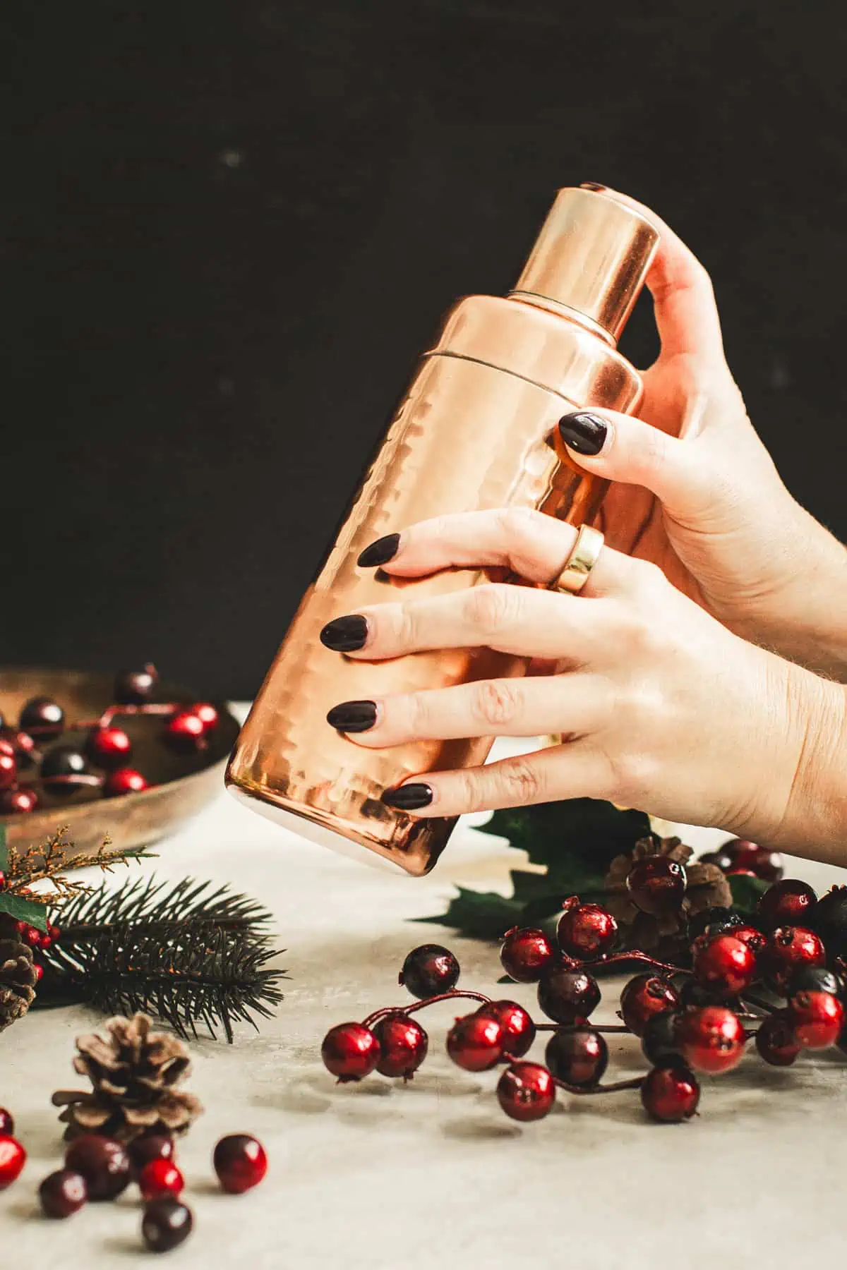 Shaking the cranberry martini in a cocktail shaker.