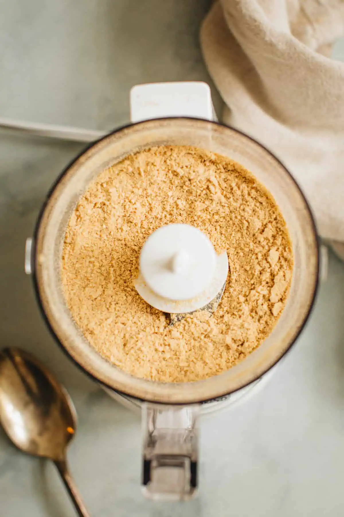 Crushed graham crackers in a food process for making Graham Cracker Crust.