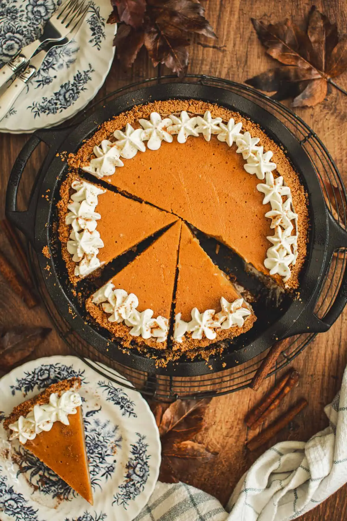 Graham cracker crust sweet potato pie topped with whipped cream in a pie dish.