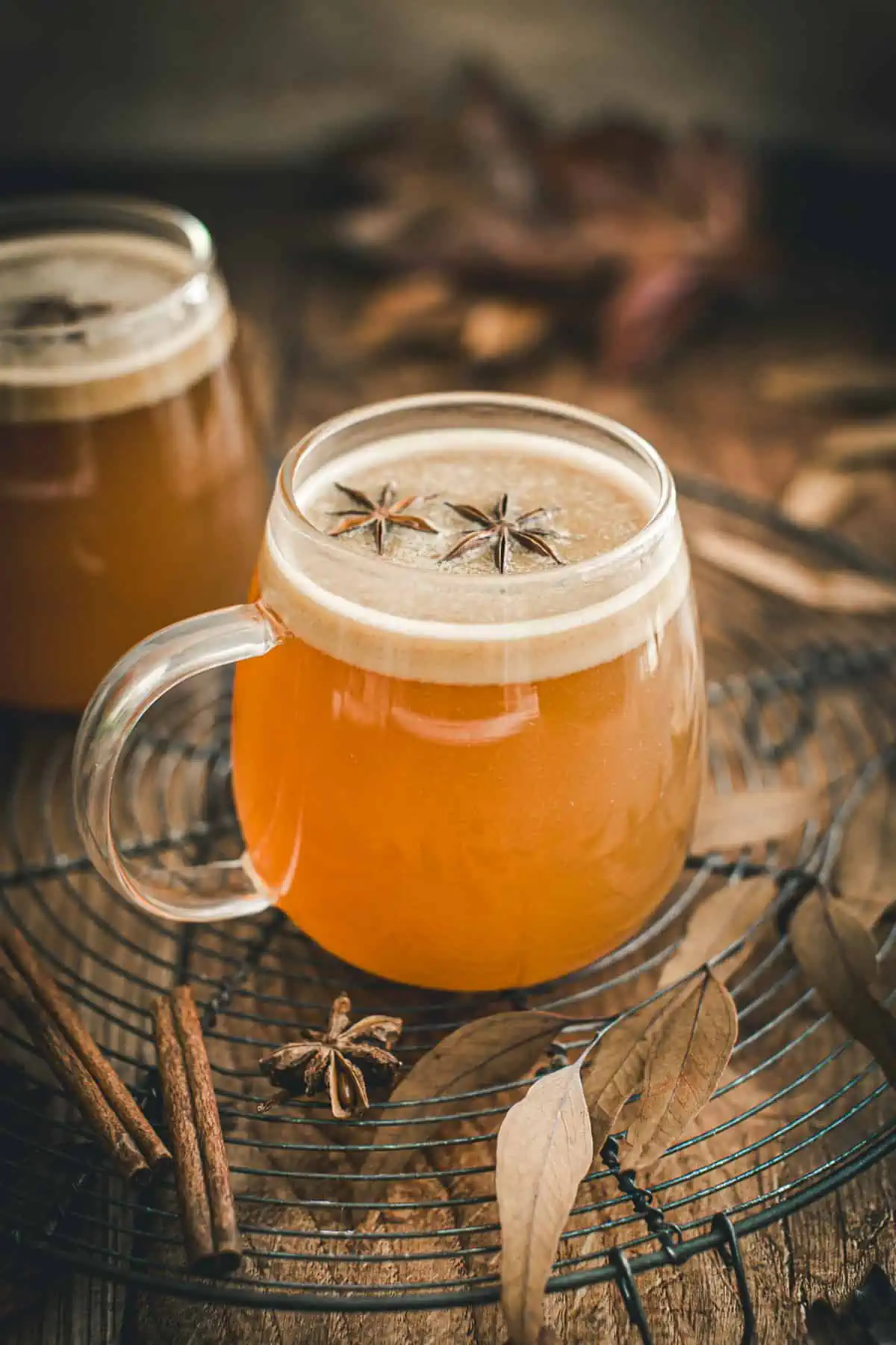 Hot buttered rum topped with star anise in a glass mug.