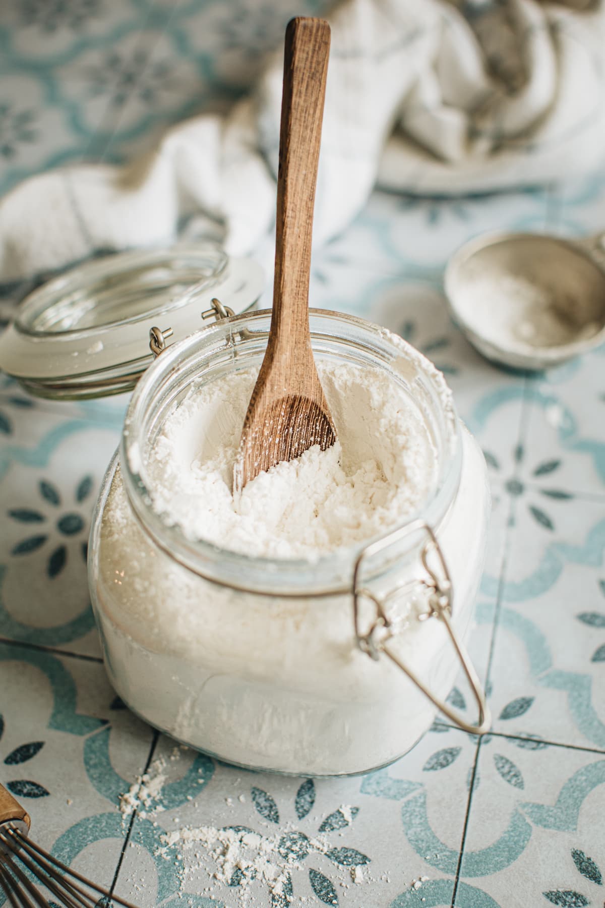 Powdered sugar in a jar with a wooden spoon in it.