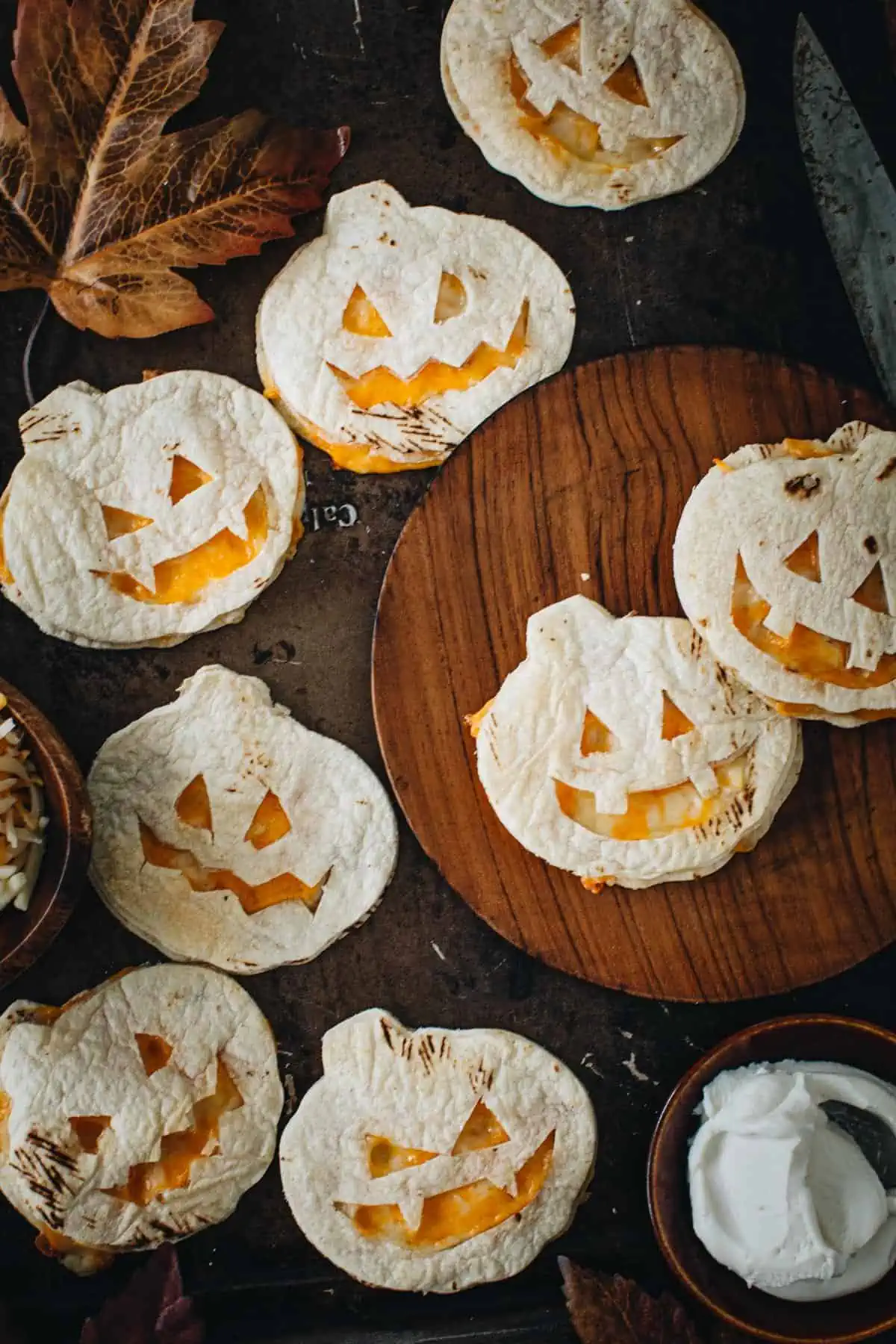 Jack-O-Lantern quesadillas on a plate and baking sheet.