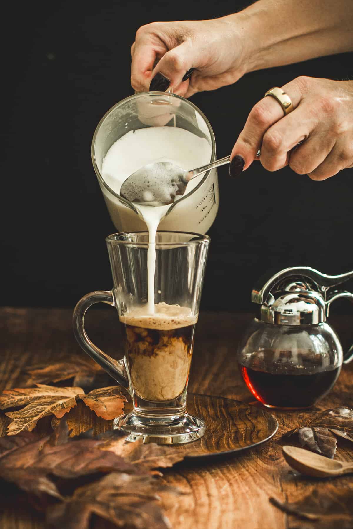 Pour steamed milk into a cup for a maple latte.