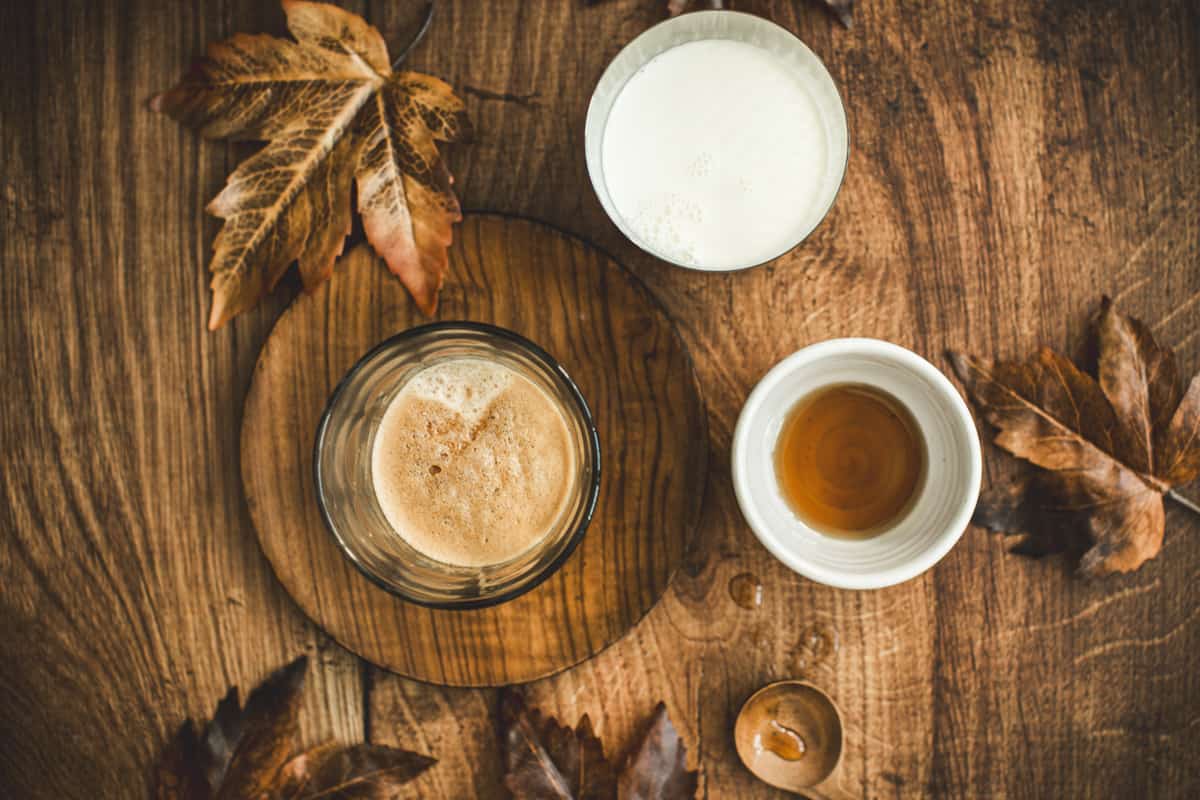 Espresso, steamed milk, and maple syrup in bowls for a maple syrup latte.