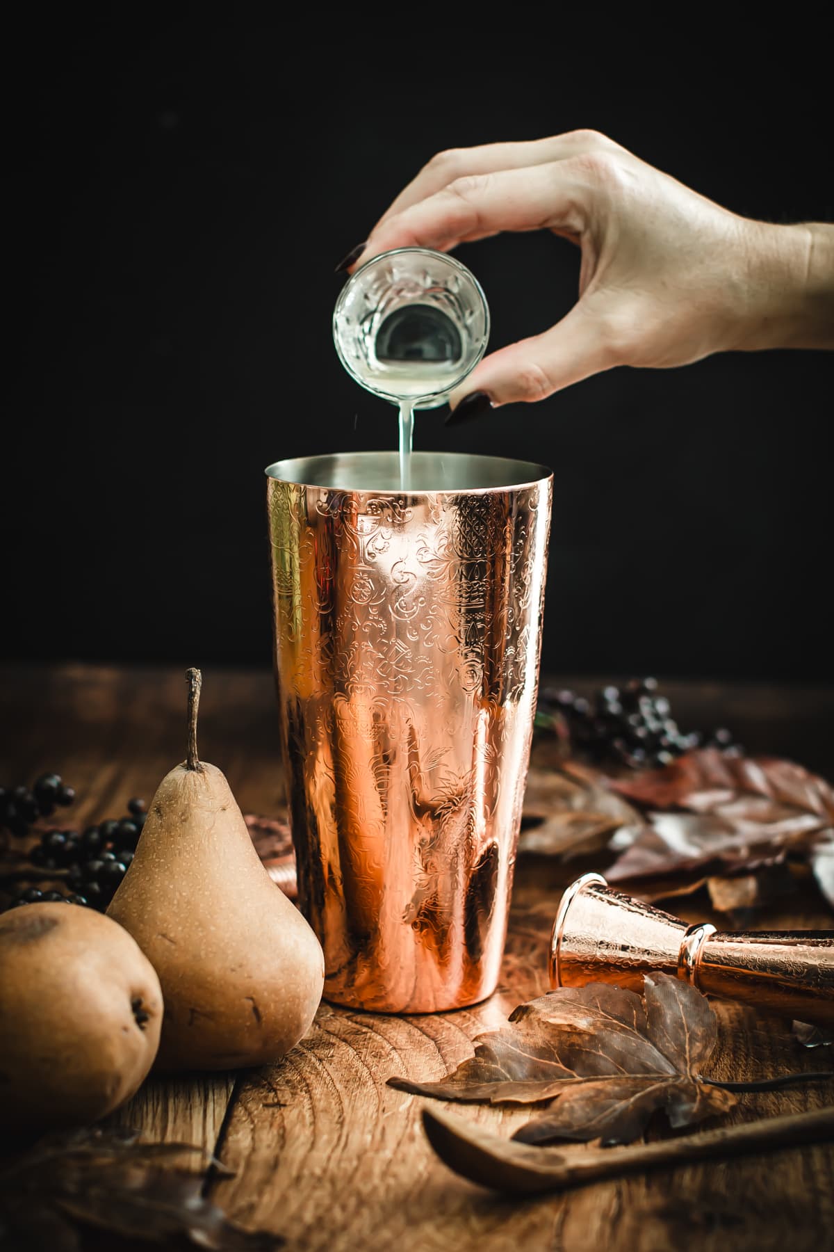 Pour lemon juice into a cocktail shaker for a pear martini.