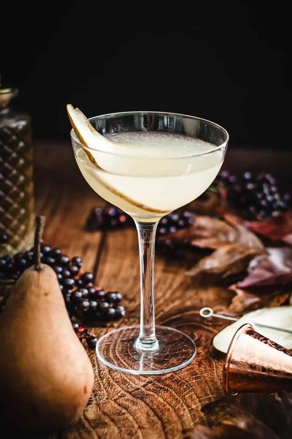 Pear martini in a glass with a fresh pear slice garnish.