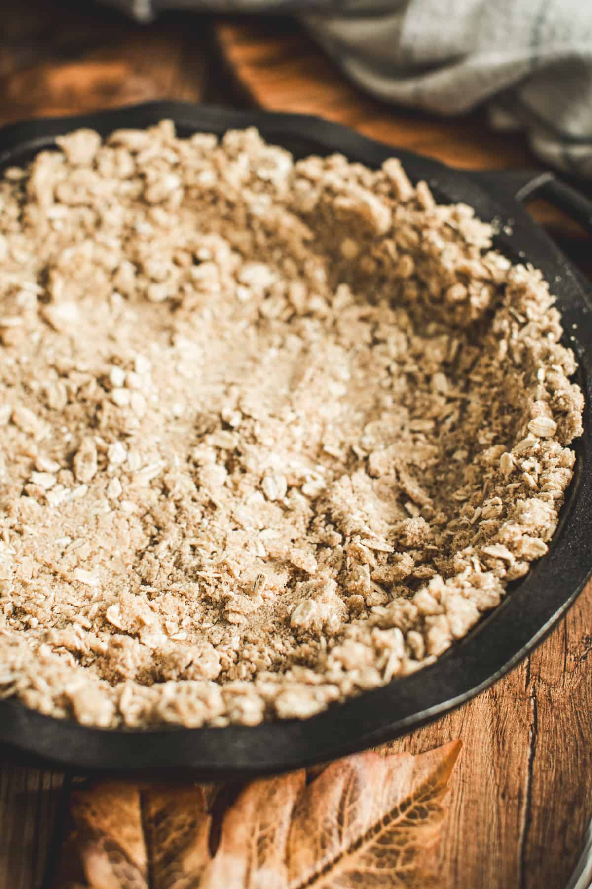 Bottom layer of the pumpkin crisp pressed into an iron pie dish.