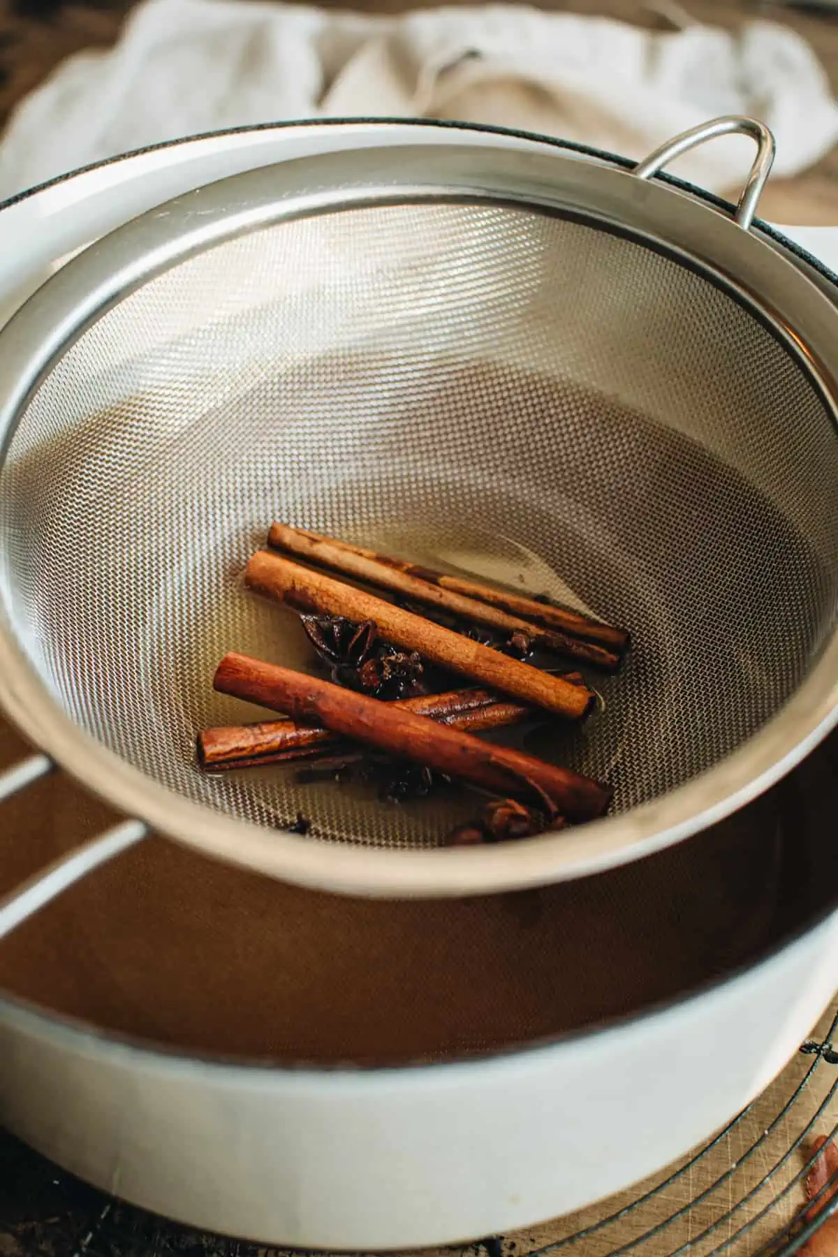 Strained cinnamon sticks and star anise for making spiked apple cider.