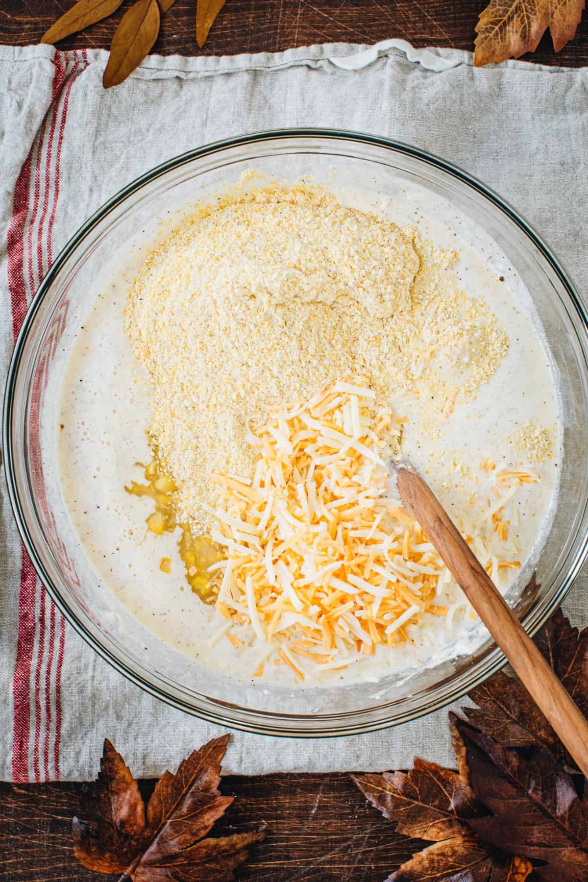 Corn, shredded cheese, and cornmeal added to the spoon bread mixture.