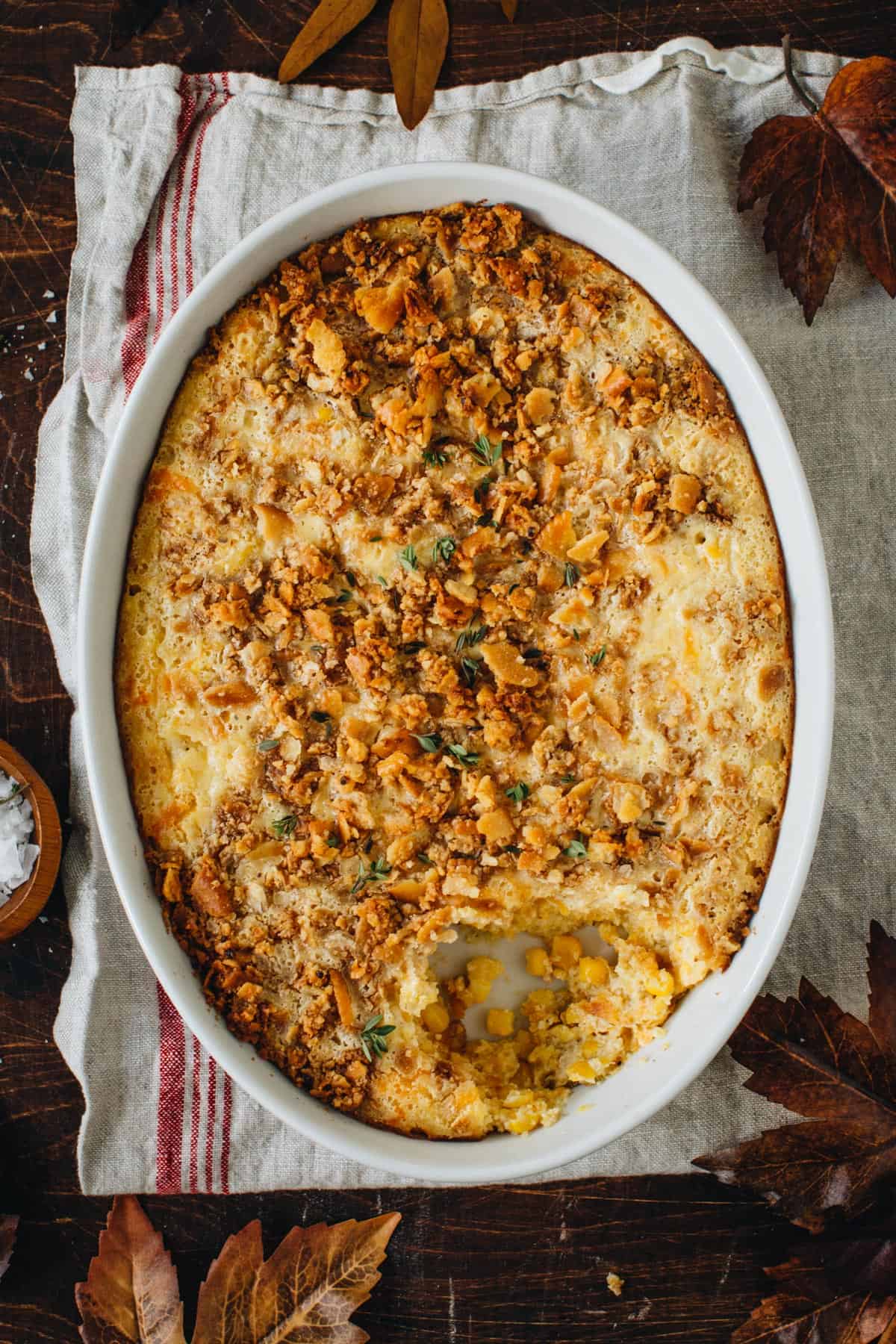 Spoonbread in a casserole dish with a scoop taken out.