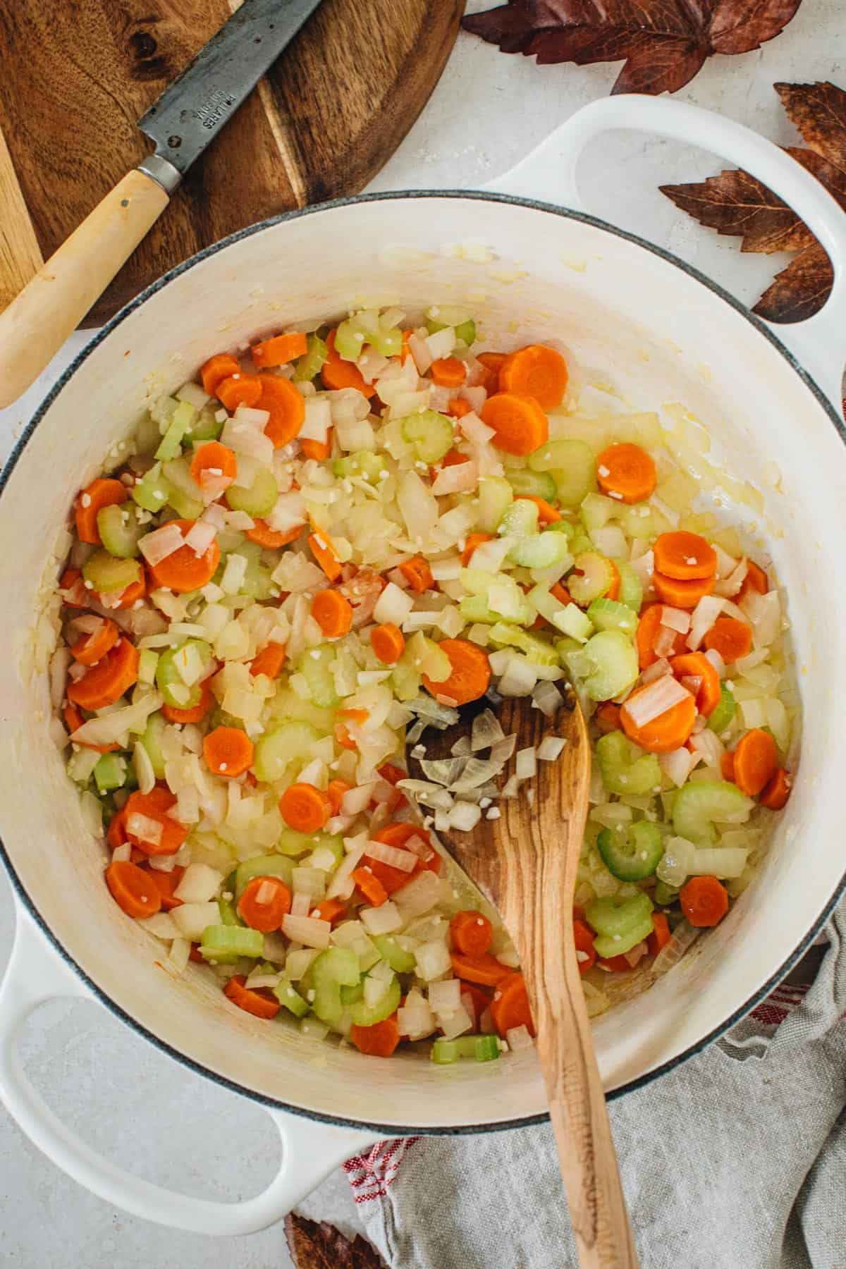 Sautéed carrots, celery, onions, and garlic in a large pot for Tuscan white bean soup.