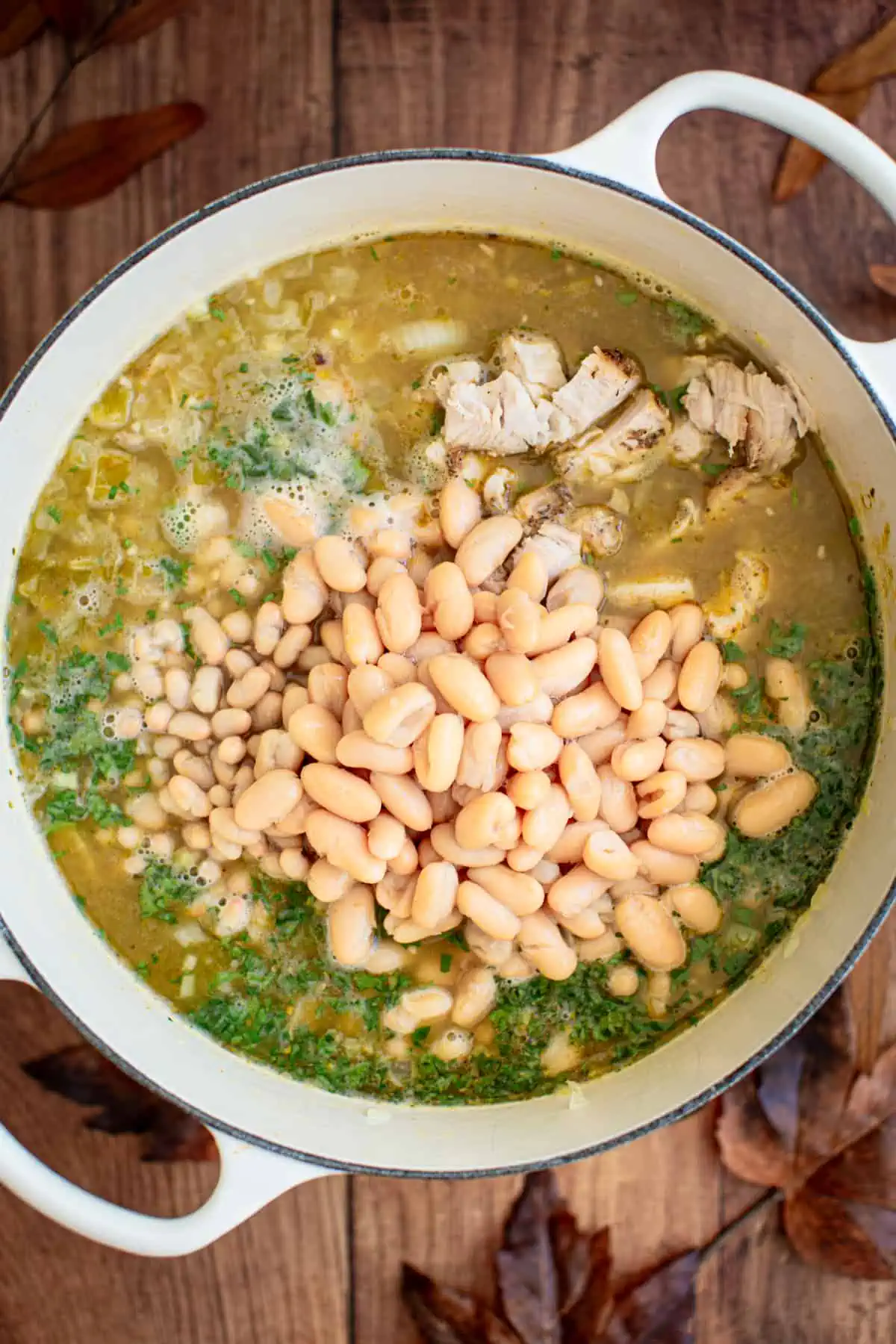 Simmering white turkey chili in a large white pot.