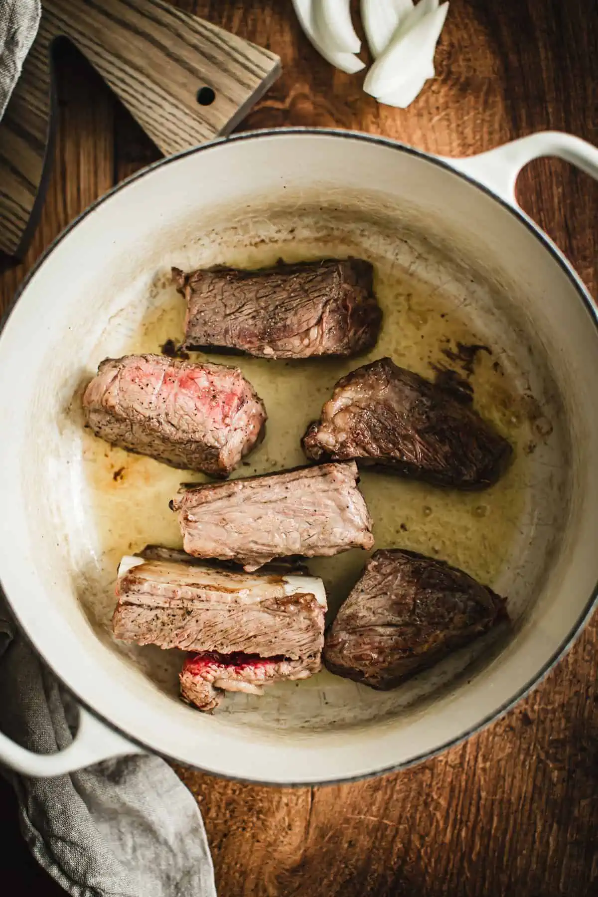 Browned beef spare ribs in a Dutch Oven for making braised short ribs.