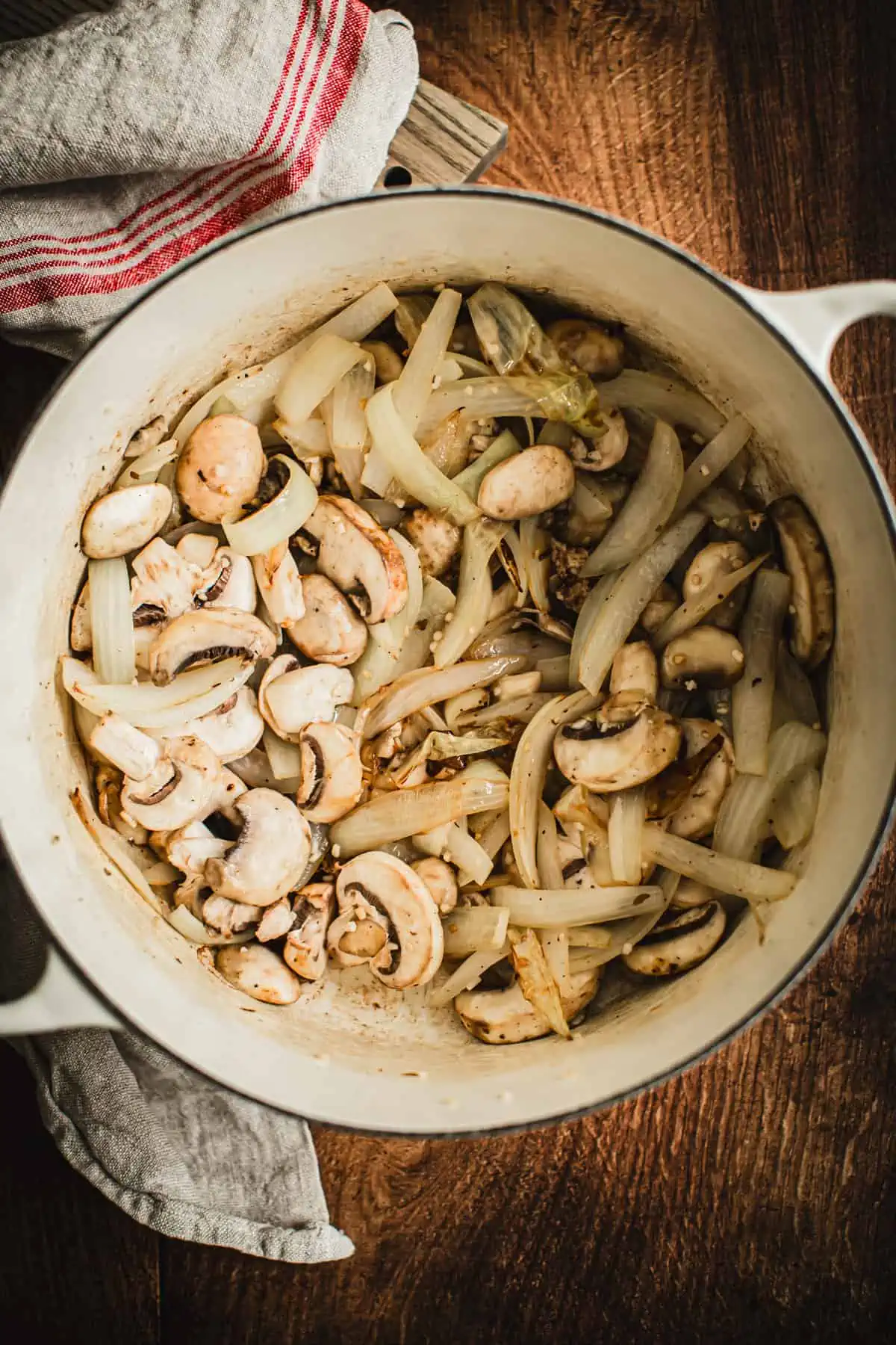 Sauteed onions, garlic, and mushrooms in a Dutch Oven for making braised short ribs.