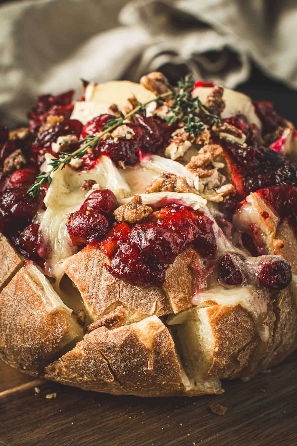 Cranberry Brie Pull-Apart Bread topped with candied pecans and fresh thyme.