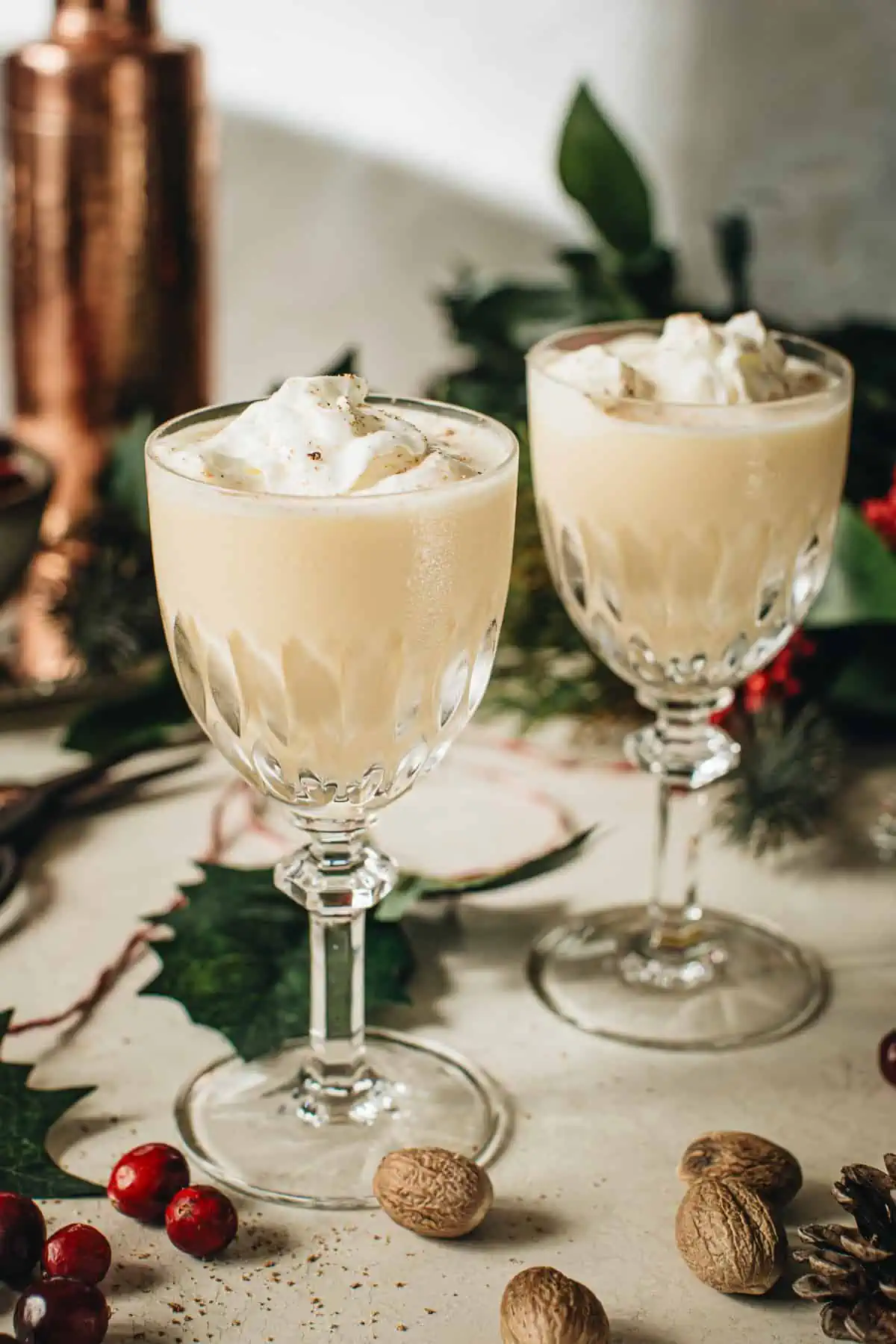 Two eggnog martinis topped with whipped cream and freshly grated nutmeg.