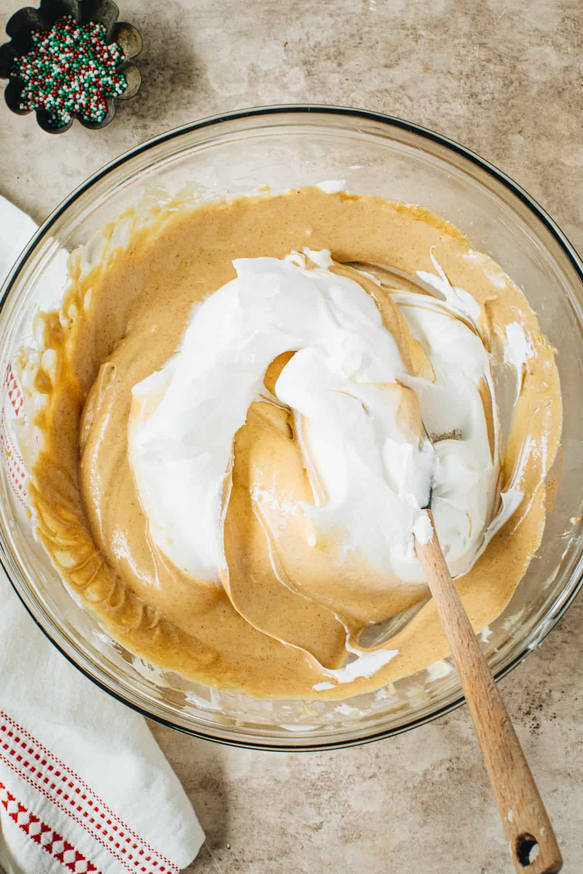 Folding whipped cream into the gingerbread cheesecake dip.
