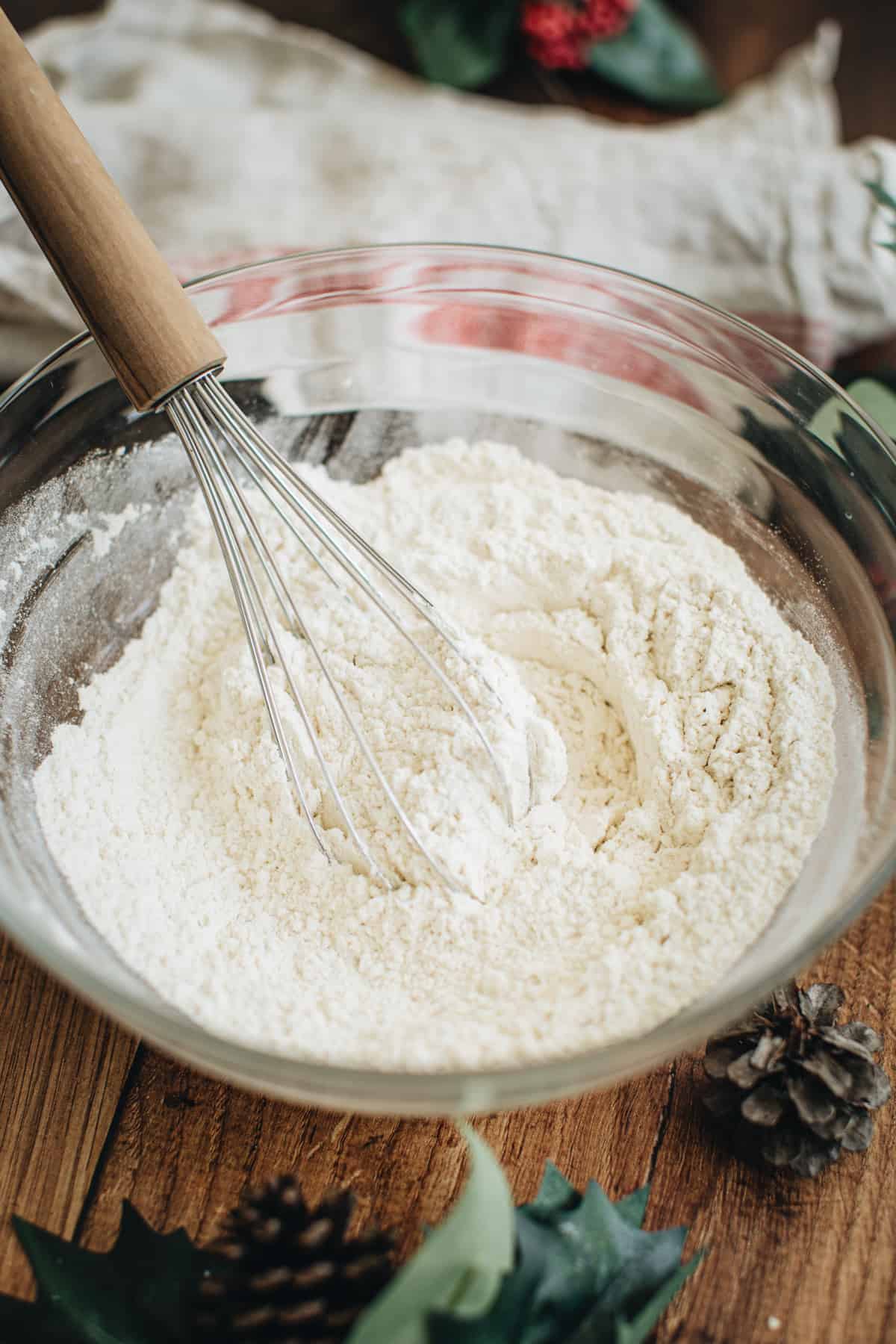 Dry ingredient mixture in a mixing bowl with a whisk sitting in the bowl for making gingerbread loaf.