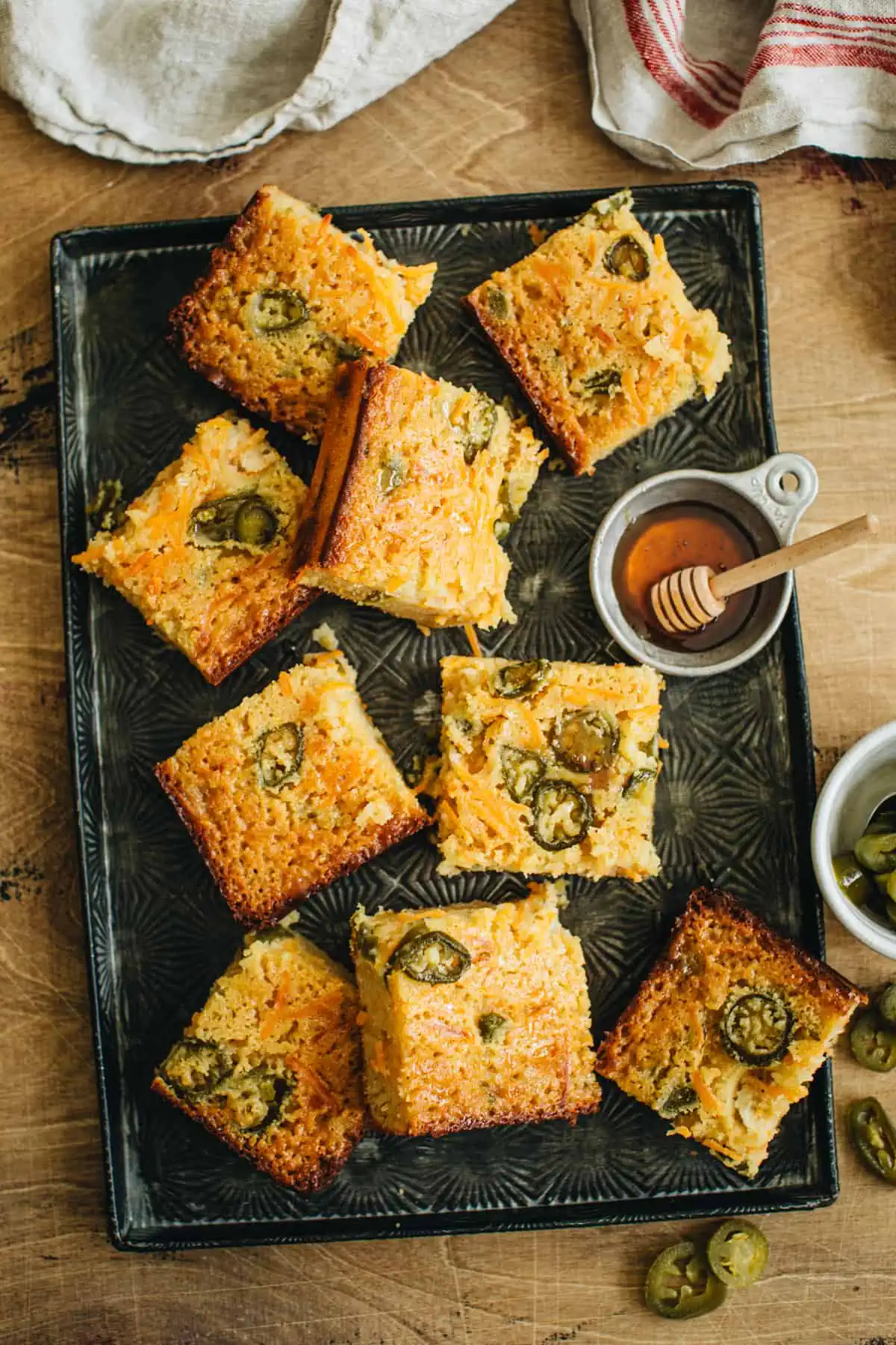 Squares of jalapeño cornbread on a baking sheet.